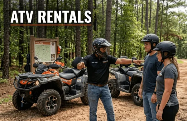 An ATV Rentals LLC expert guide conducting a safety briefing and body positioning demonstration on a wooded Conroe trail near Houston, Texas. A small group of attentively geared riders observes properly equipped two-seater ATVs, reinforcing safe and structured beginner experiences